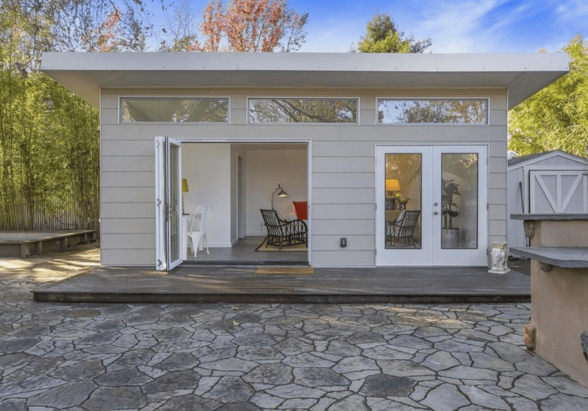 Modern white detached ADU with shiplap siding, clerestory windows, french doors, and flagstone patio in San Jose