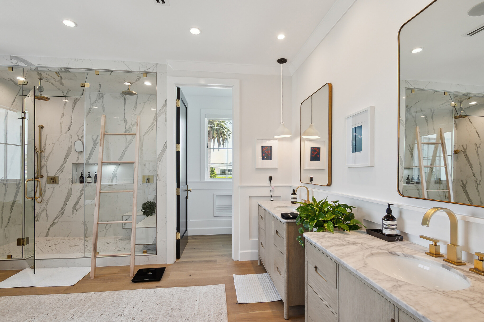 Los Angeles 806 primary bathroom with marble shower, gold fixtures, and dual vanities