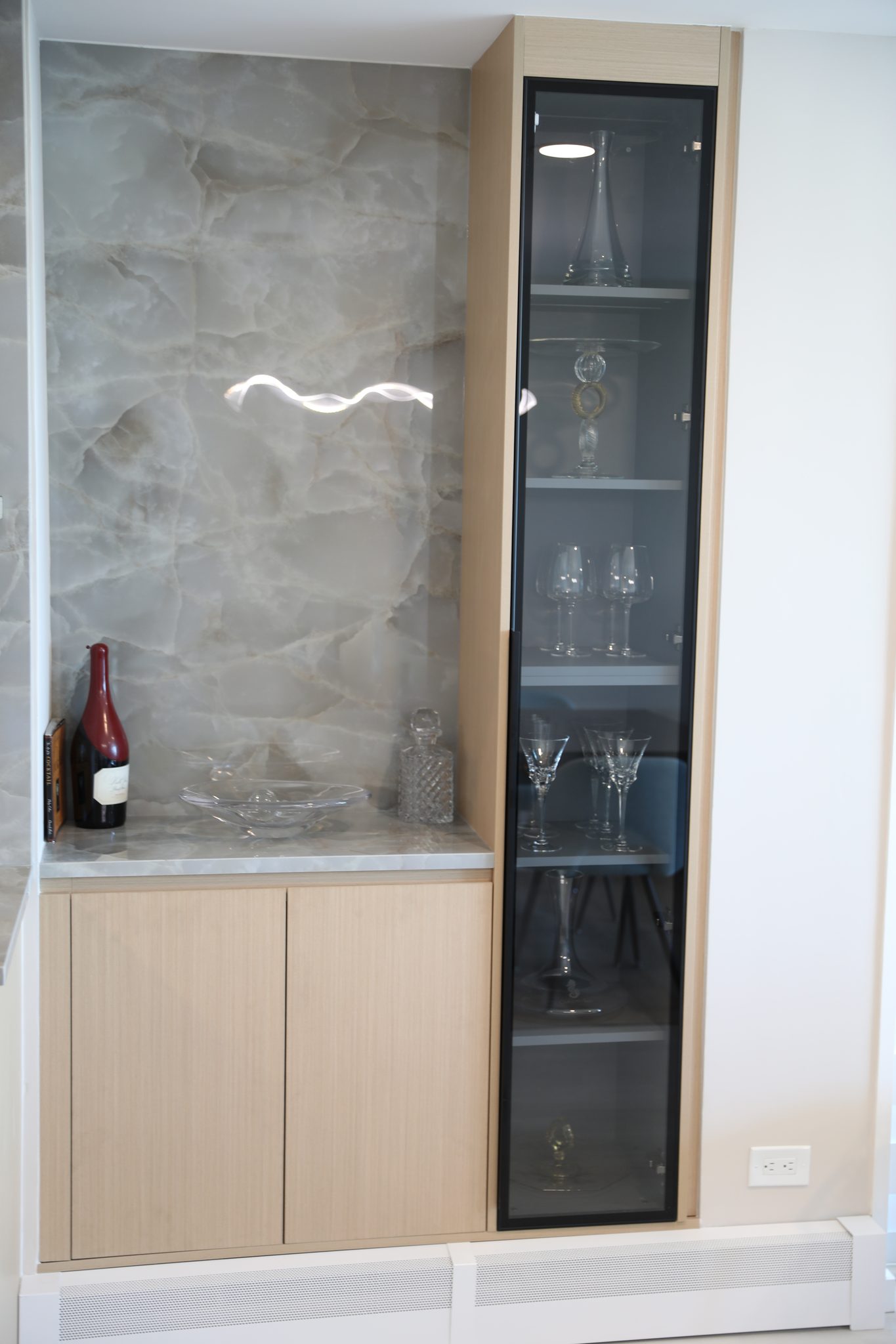 Tall glass cabinet and stone bar niche