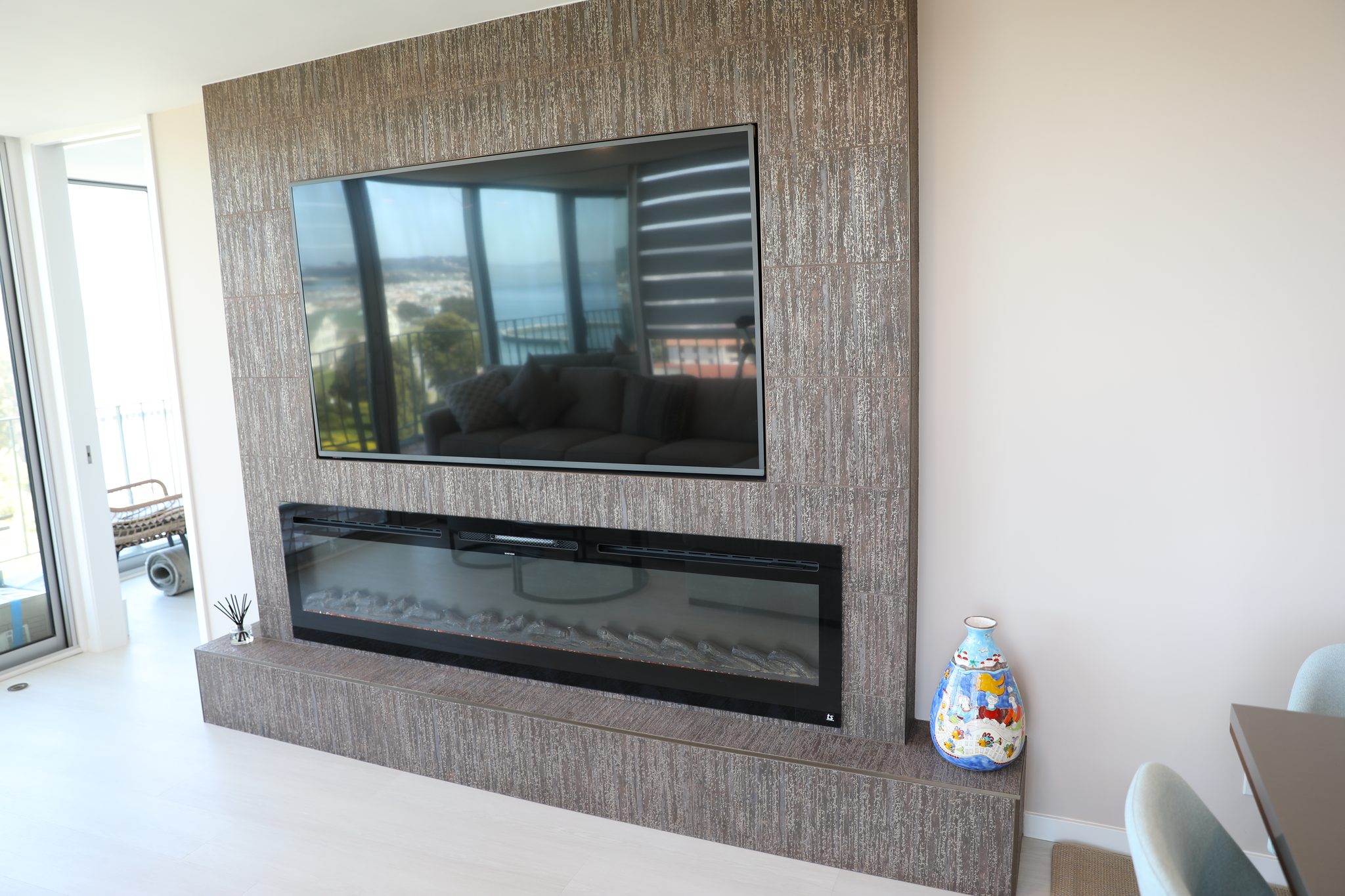 Stone fireplace wall with linear fireplace and TV