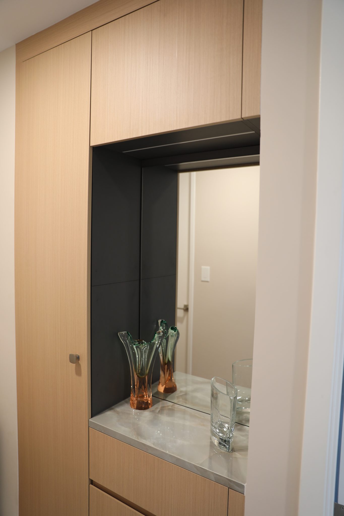 Hall millwork with oak cabinets and a stone niche