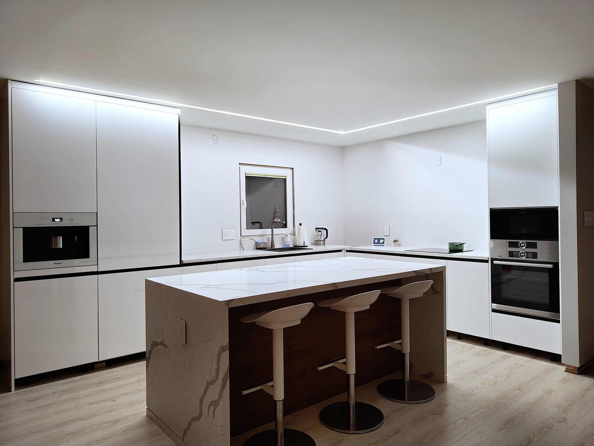 San Jose 669 kitchen, white cabinets, marble island, and cove lighting