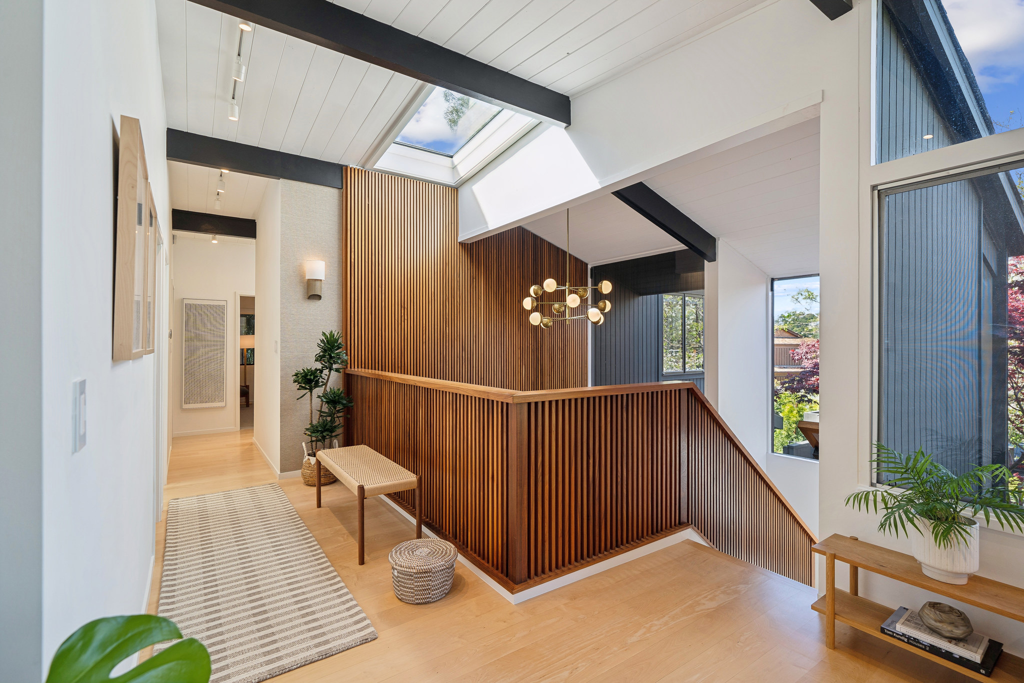 Upstairs hall with wood slat stair and skylight
