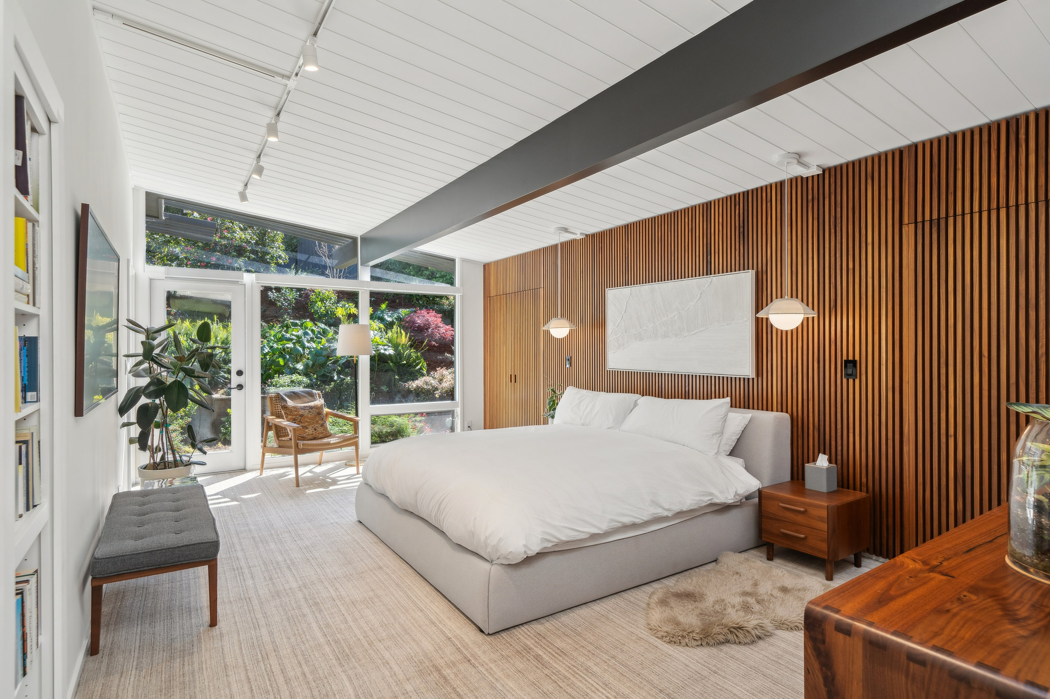 Primary bedroom with wood slat wall and garden doors