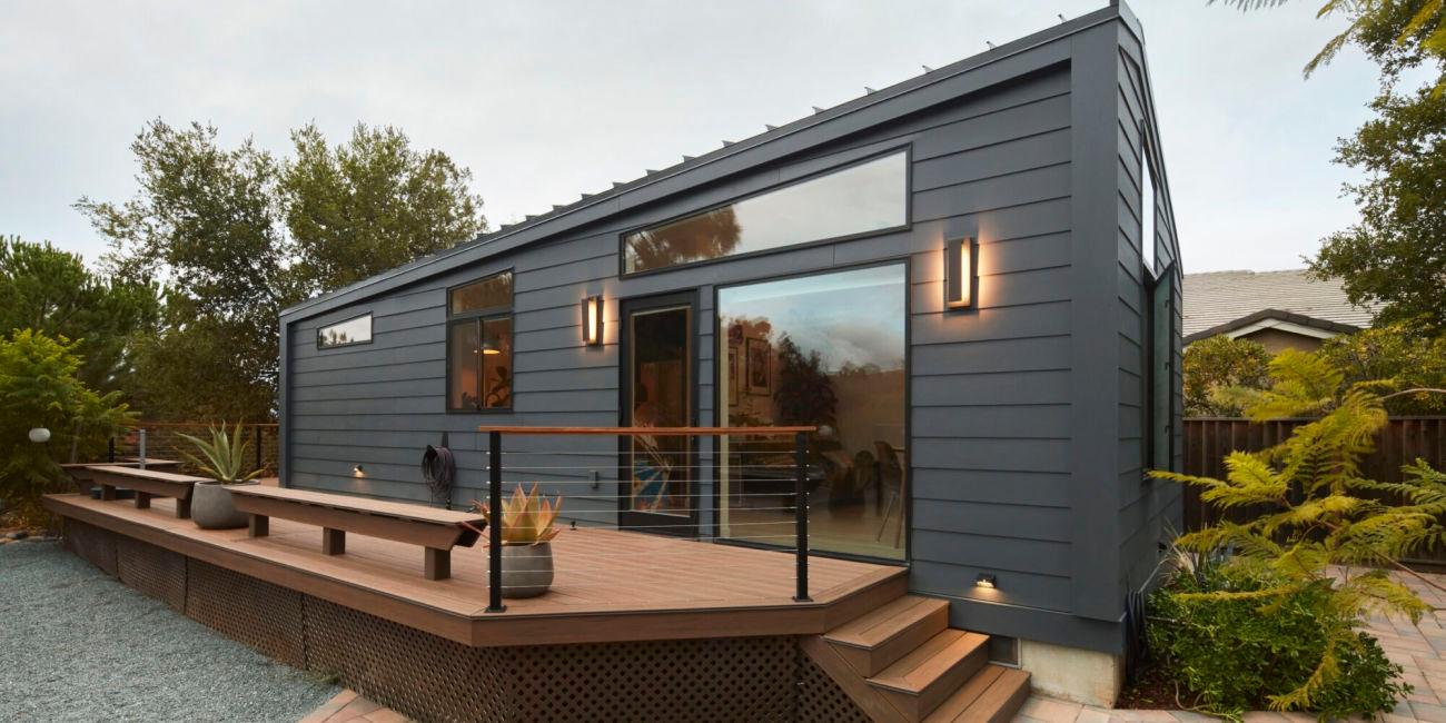 Modern dark grey ADU with large windows, deck, and cable railing in San Jose